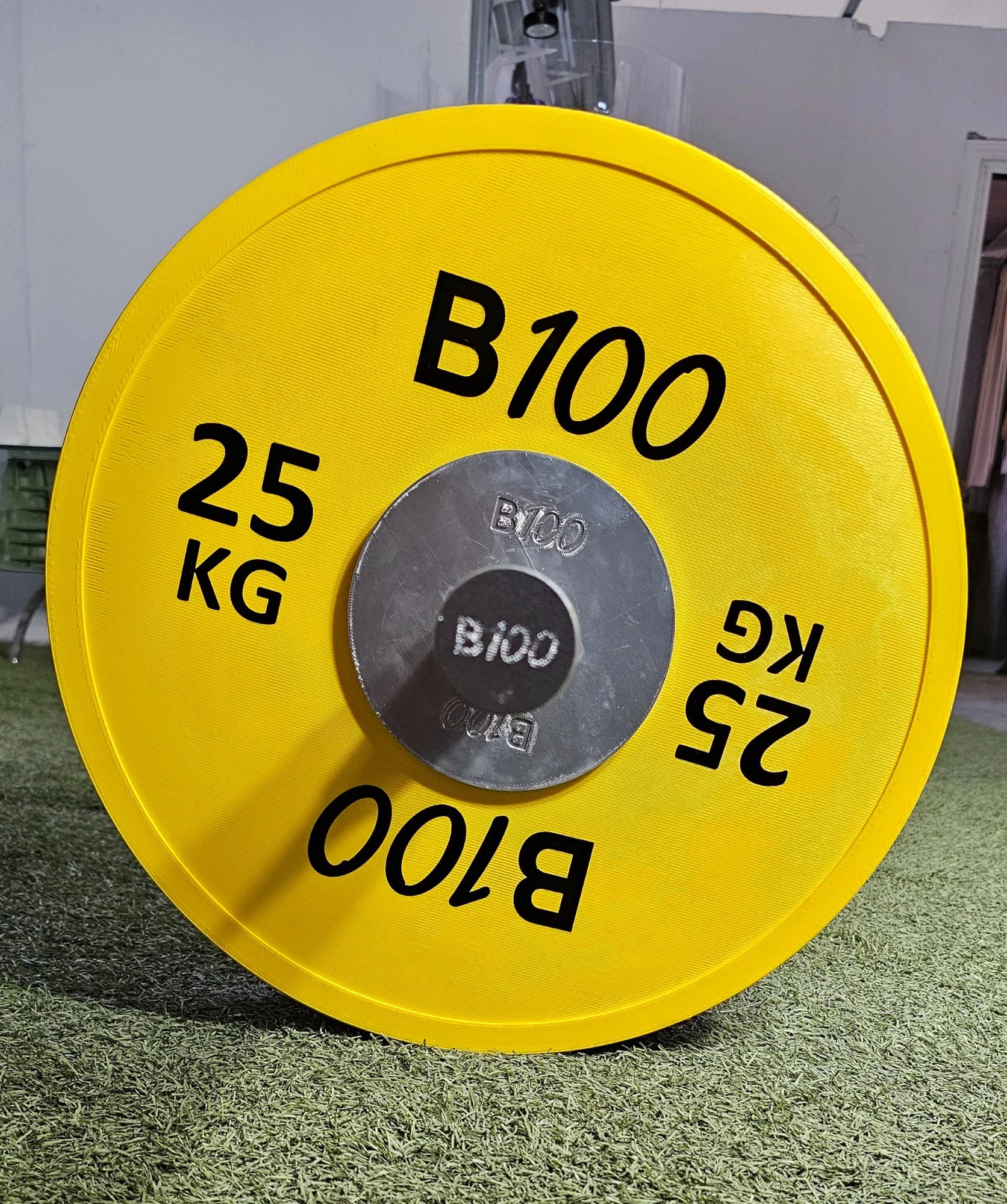 Primer plano del disco amarillo B100 de 25 kg
